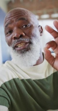 Yaşlı bir Afrikalı Amerikalı 'nın kameraya bir öpücük gönderirken çekilmiş dikey görüntüsü. Son sınıf ve teknoloji konsepti.