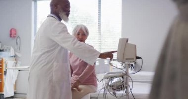Afrika kökenli Amerikalı erkek doktor, hastanedeki beyaz kadın hastayı muayene ediyor. Tıp, sağlık, yaşam tarzı ve hastane konsepti.