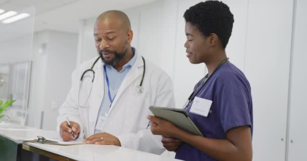 Afro Amerikan Erkek Kadın Doktorlar Ellerinde Dosya Tablet Hastanede Konuşuyorlar — Stok video