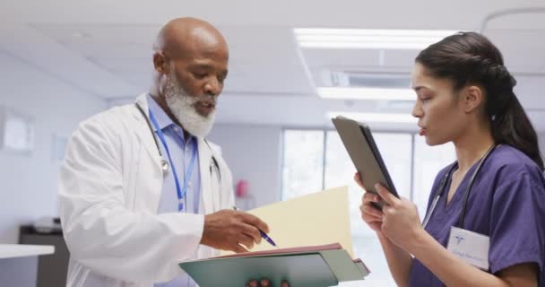 Zróżnicowani Lekarze Trzymający Notatnik Tablet Rozmawiający Szpitalu Medycyna Opieka Zdrowotna — Wideo stockowe