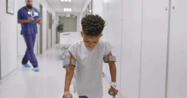 Médico Afro Americano Caminhando Com Paciente Infantil Usando Muletas Hospital — Vídeo de Stock