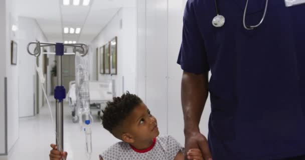 非洲裔美国男性医生与儿童病人一起在医院行走 生活方式和医院概念 — 图库视频影像