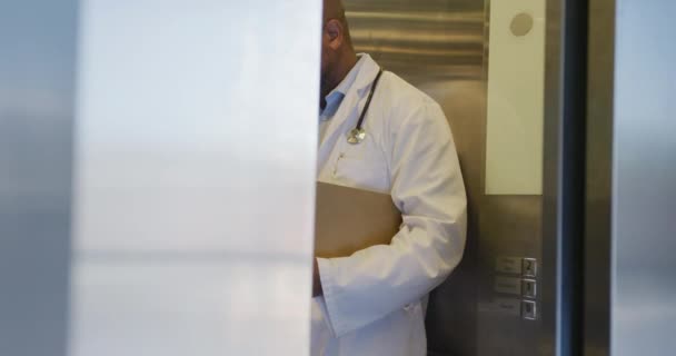非洲裔美国男性医生离开电梯 在医院使用智能手机 生活方式和医院概念 — 图库视频影像