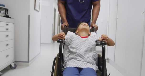 Médico Afro Americano Caminhando Com Paciente Infantil Sentado Cadeira Rodas — Vídeo de Stock