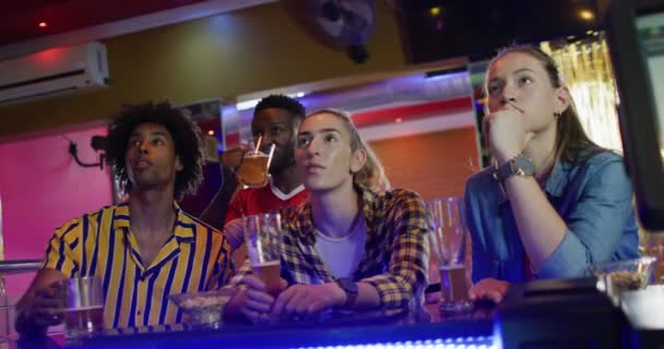 Farklı Arkadaş Gruplarının Bir Barda Ekranda Spor Oyununa Tepki Verdiklerini — Stok video
