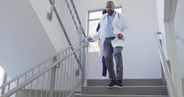 非洲裔美国男女医生走在医院的楼梯上 生活方式和医院概念 — 图库视频影像