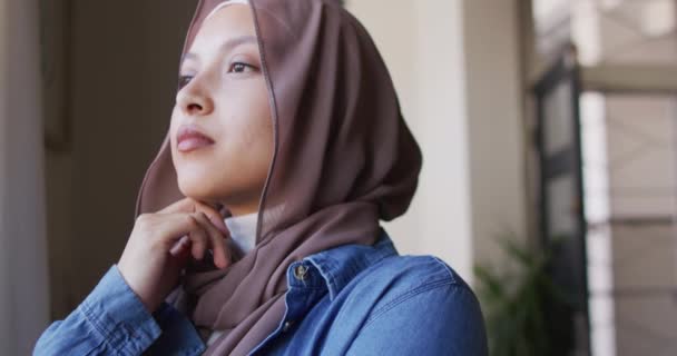 Evde Pencereden Dışarı Bakan Tesettürlü Düşünceli Melez Kadının Videosu Rahatlama — Stok video