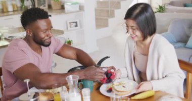 Masada oturup kahvaltı eden mutlu çift. Ev kavramında kaliteli zaman geçirmek.