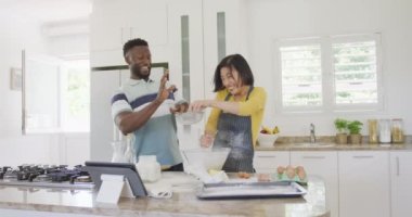 Önlük giyip mutfakta yemek pişiren mutlu çift. Ev kavramında kaliteli zaman geçirmek.