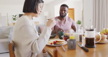 Masada oturup kahvaltı eden mutlu çift. Ev kavramında kaliteli zaman geçirmek.