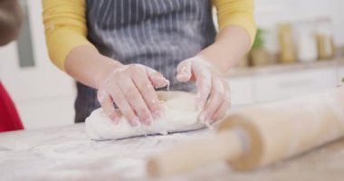 Önlük giyip mutfakta yemek pişiren çiftlere yakın durun. Ev kavramında kaliteli zaman geçirmek.