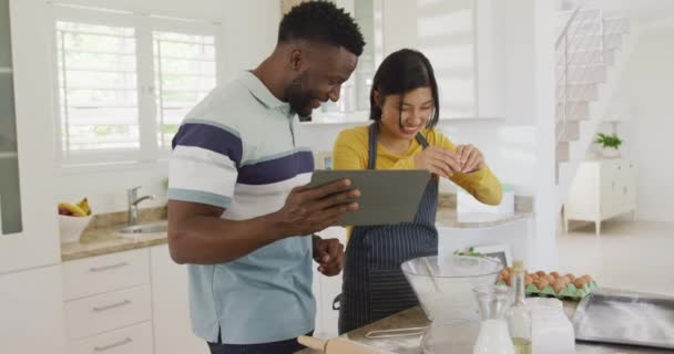 Happy Diverse Couple Using Tablet Baking Kitchen Spending Quality Time — Vídeo de stock