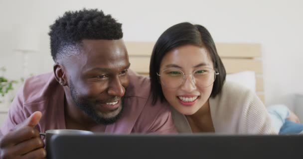 Happy Diverse Couple Using Laptop Lying Bedroom Spending Quality Time — Vídeo de Stock