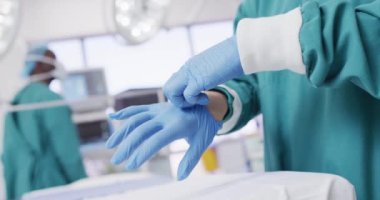 Video of midsection of surgeon putting on surgical gloves in operating theatre. Hospital, medical and healthcare services.