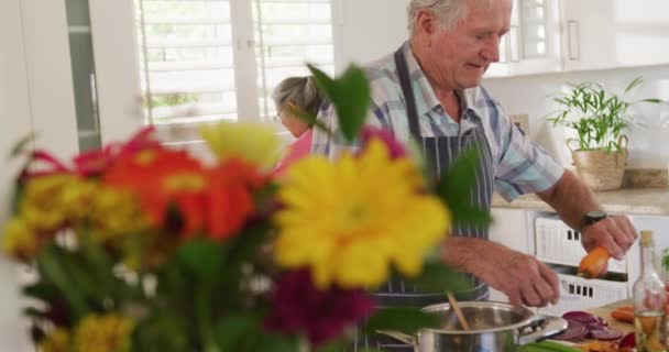 Ευτυχισμένο Ζευγάρι Ηλικιωμένων Που Φορούν Ποδιές Και Μαγειρεύουν Στην Κουζίνα — Αρχείο Βίντεο