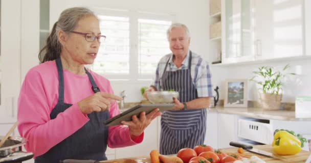 Ευτυχισμένο Ζευγάρι Ηλικιωμένων Χρησιμοποιώντας Tablet Και Μαγείρεμα Στην Κουζίνα Έννοια — Αρχείο Βίντεο