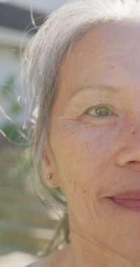 Güneşli bir günde, mutlu Asyalı son sınıf öğrencisinin portresinin dikey videosu. Etkin emeklilik ve yaşam tarzı kavramı.