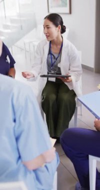 Vertical video of diverse doctors sitting and discussing. Global medicine, health, lifestyle and hospital concept.