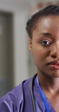 Vertical video of portrait of happy african american female doctor. Global medicine, health, lifestyle and hospital concept.