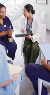 Vertical video of diverse doctors sitting and discussing. Global medicine, health, lifestyle and hospital concept.