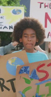 Farklı sınıf arkadaşlarıyla protesto eden Afrikalı Amerikalı bir çocuğun dikey videosu. Kopya alanı. Eğitim, çocukluk, kapsayıcılık, ekoloji, iletişim, okul ve öğrenim kavramı.
