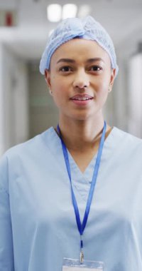 Vertical video of portrait of happy biracial female doctor. Global medicine, health, lifestyle and hospital concept.