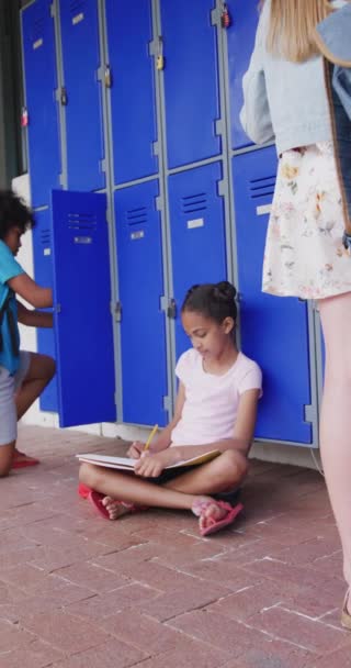 Video Vertikal Anak Sekolah Birasial Duduk Lantai Menulis Koridor Sekolah — Stok Video