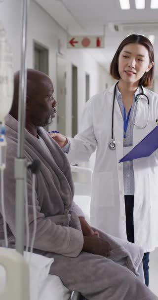 Κατακόρυφο Βίντεο Ασιάτισσας Γιατρού Αφροαμερικανό Ασθενή Μιλάει Παγκόσμια Ιατρική Υγεία — Αρχείο Βίντεο