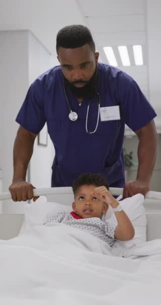 Κατακόρυφο Βίντεο Αφροαμερικανό Γιατρό Περπατάει Παιδί Ασθενή Στο Νοσοκομείο Ιατρική — Αρχείο Βίντεο