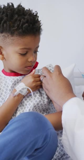 Κατακόρυφο Βίντεο Αφροαμερικανού Γιατρού Που Εμβολιάζει Παιδιατρικό Ασθενή Στο Νοσοκομείο — Αρχείο Βίντεο