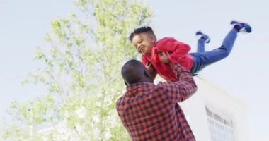 Happy african american father and his son playing in garden. Spending quality time at home.