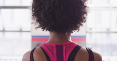 Video of rear view of african american woman working out at a gym doing kettlebell swings. Exercise, fitness and healthy lifestyle.