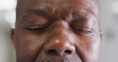 Açılış portresi, göz kırpan yaşlı Afro-Amerikan erkek. 