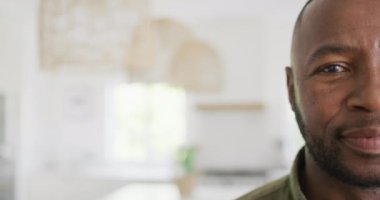 Portrait of happy african american man looking at camera and smiling. Spending quality time at home, childhood and family concept.