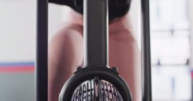 Video close up of determined african american woman on exercise bike working out at a gym. Exercise, fitness and healthy lifestyle.