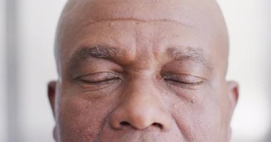 Video close up portrait of the opening eyes of senior african american male doctor. Hospital, medical and healthcare services.