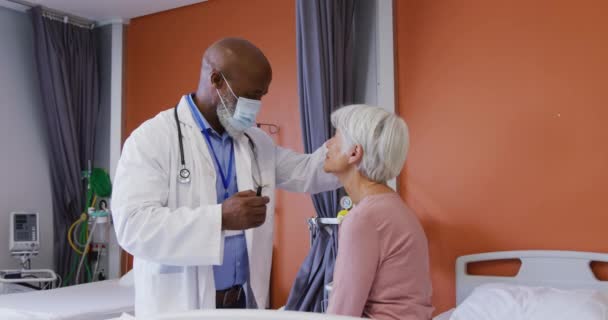 Afroameričtí Lékaři Pomocí Baterky Vyšetřují Oči Starší Bělošky Pacientky Medicína — Stock video