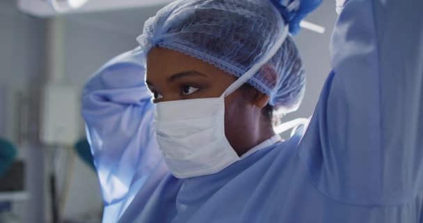 Video African American Female Surgeon Tying Face Mask Operating Theatre — Stockvideo