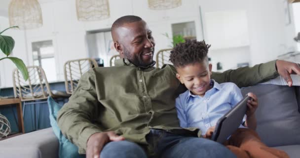 Happy African American Man His Son Sitting Sofa Using Tablet — Vídeos de Stock
