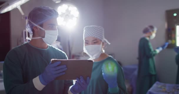 Video Diverse Male Female Surgeon Discussion Looking Tablet Operating Theatre — Video