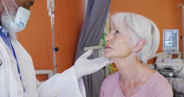 在医院检查老年白人女病人颈部的非裔美国男性医生 生活方式和医院概念 — 图库视频影像
