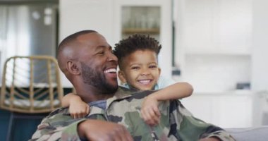 Portrait of happy african american father and his son embracing. Spending quality time at home.