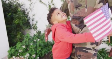 Happy african american father and his son embracing in garden. Spending quality time at home.