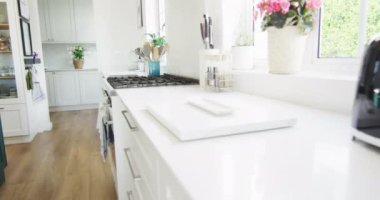 Modern, lüks bir ev mutfağı, beyaz üniteler, ahşap döşeme, kopyalama alanı. İç tasarım ve ev hayatı.