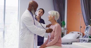 İki farklı doktor, hastanede konuşan Kafkas kadın hastayı muayene ediyor. Tıp, sağlık, yaşam tarzı ve hastane konsepti.