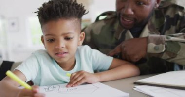 African american father with son learning together and writing. Spending quality time together, army and patriotism concept.