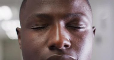 Video close up portrait of the opening eyes of african american male medical worker. Hospital, medical and healthcare services.