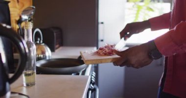 Mid section of senior african american man spending time in log cabin, cooking in kitchen. Free time, domestic life and nature concept.