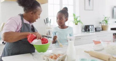 Afro-Amerikan büyükanneniz ve torununuz mutfakta yemek pişirip, fotokopi çekerken eğleniyor. Aile, sağlık, birliktelik ve aile hayatı..
