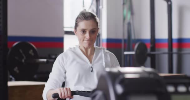 Video Determined Caucasian Woman Using Rowing Machine Working Out Gym — Stock videók